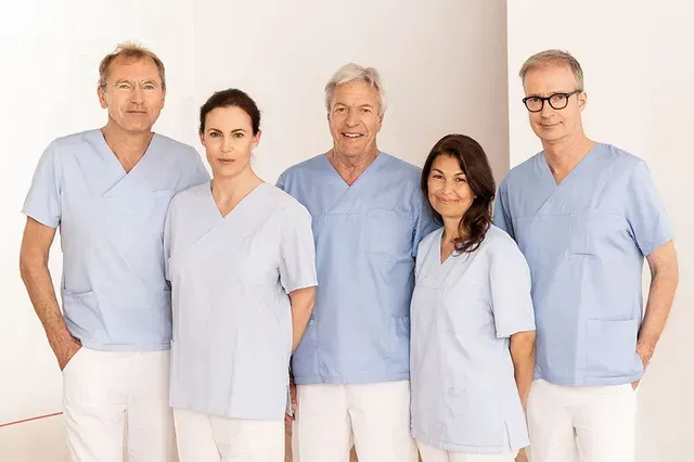 Eine Gruppe von Menschen in OP-Kleidung posiert für ein Foto.