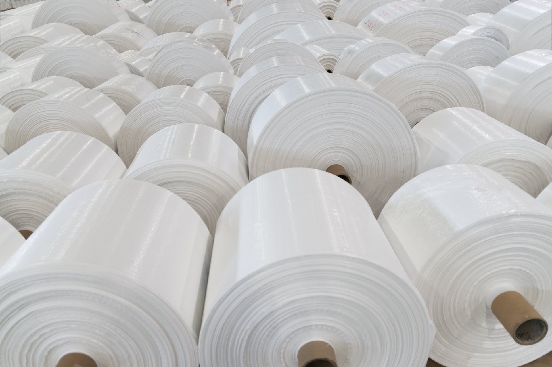 Un tas de rouleaux de papier blanc sont empilés les uns sur les autres.