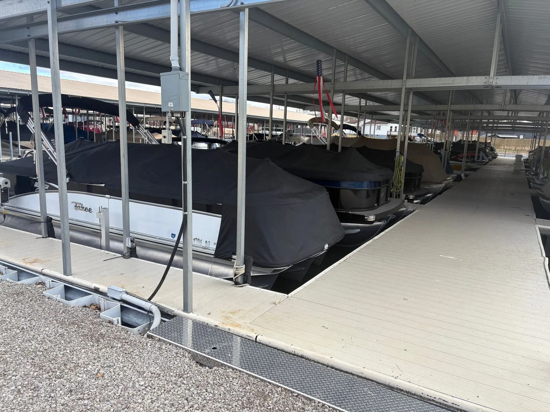 Covered boat storage with several boats on trailers under a metal roof