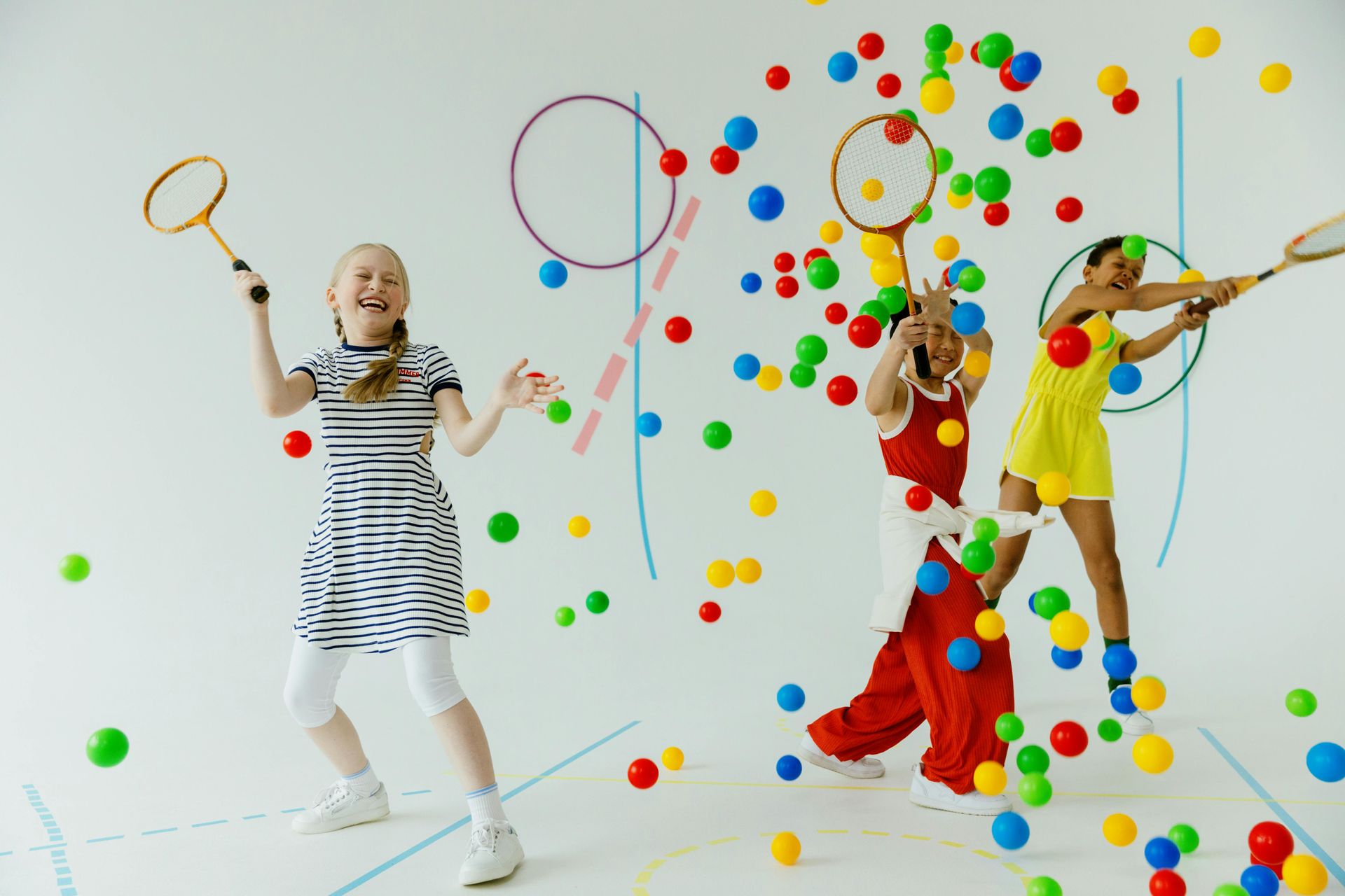 Girls playing with rracquets and colorful balls