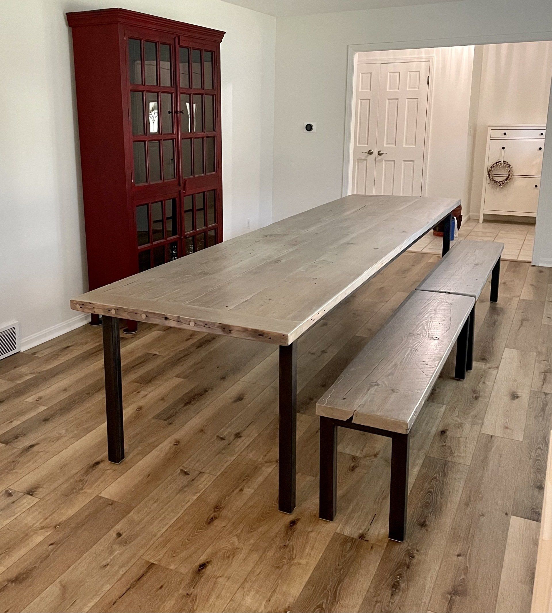 A long wooden table with two benches in a living room.