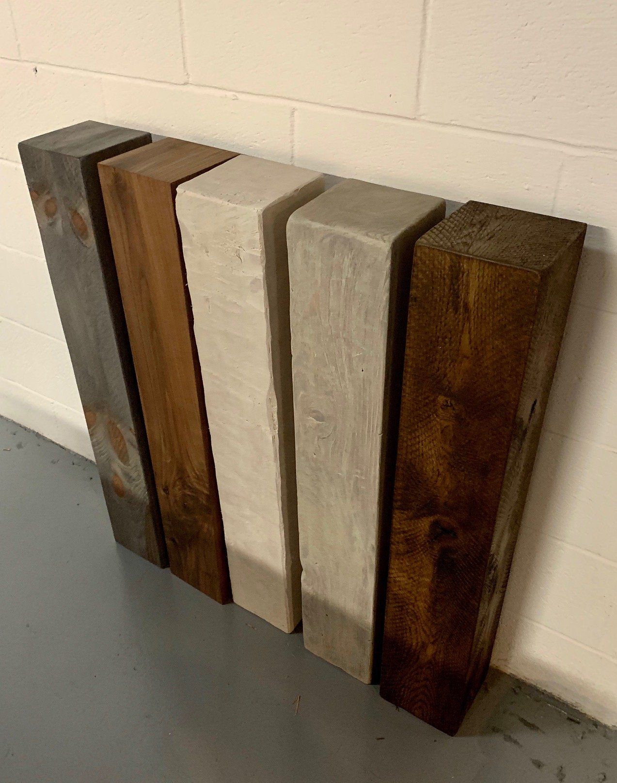 A group of wooden beams sitting next to each other in front of a brick wall.