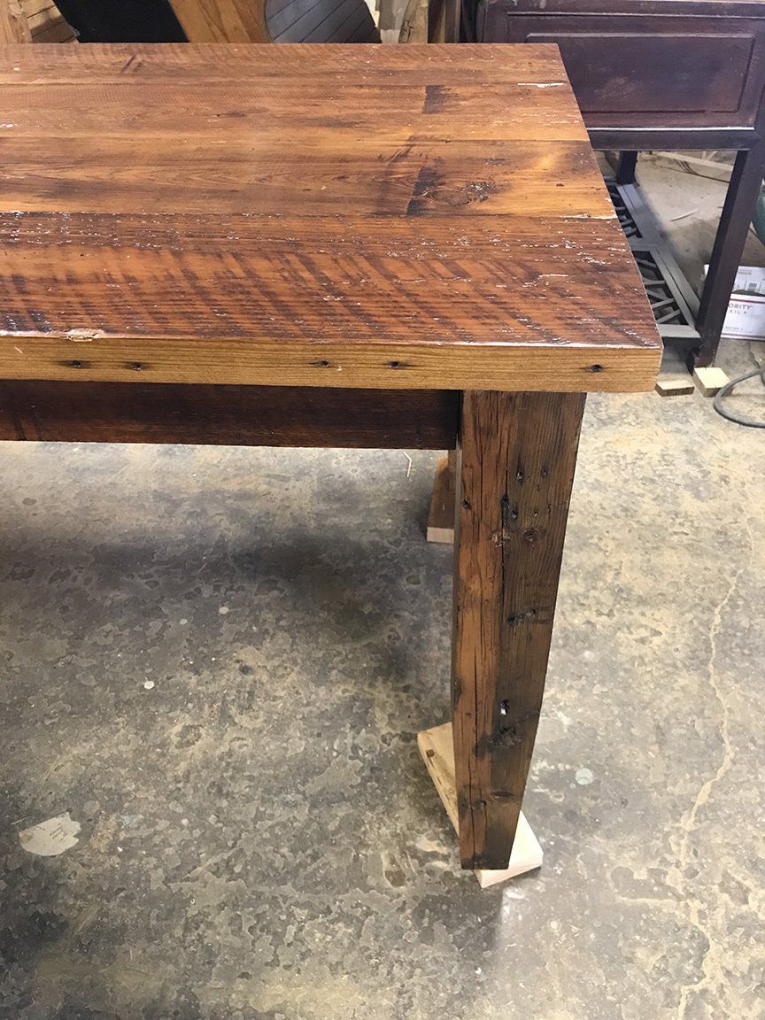 A wooden table is sitting on a concrete floor.