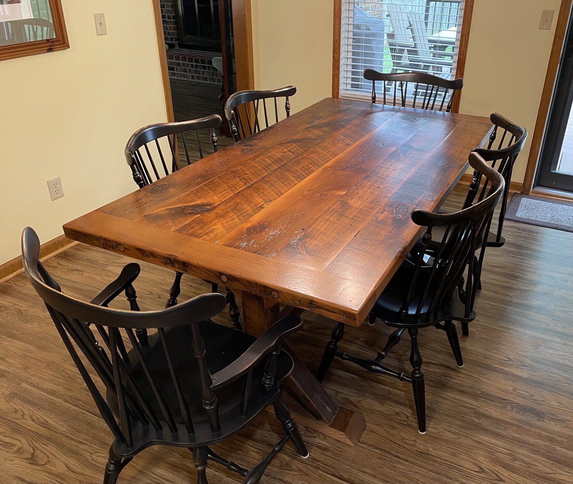 A wooden dining table with black chairs in a dining room.