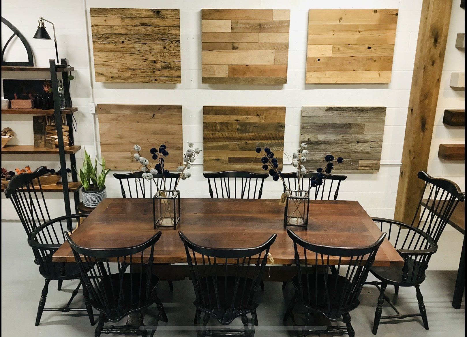 A dining room table and chairs in front of a wall with wooden panels on it.