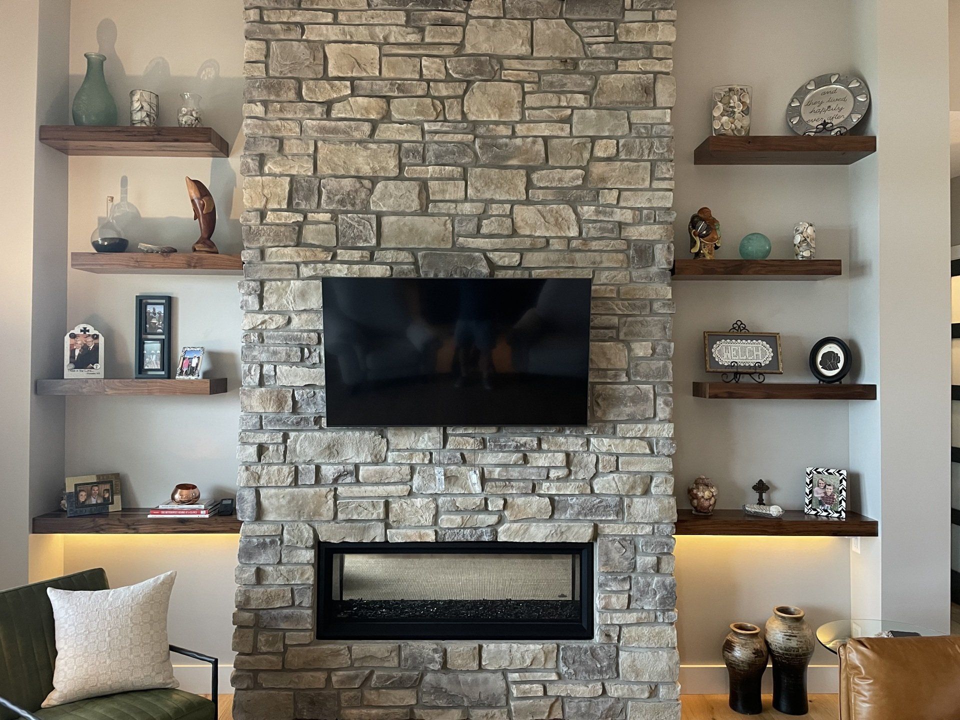 A living room with a fireplace and a flat screen tv on the wall.