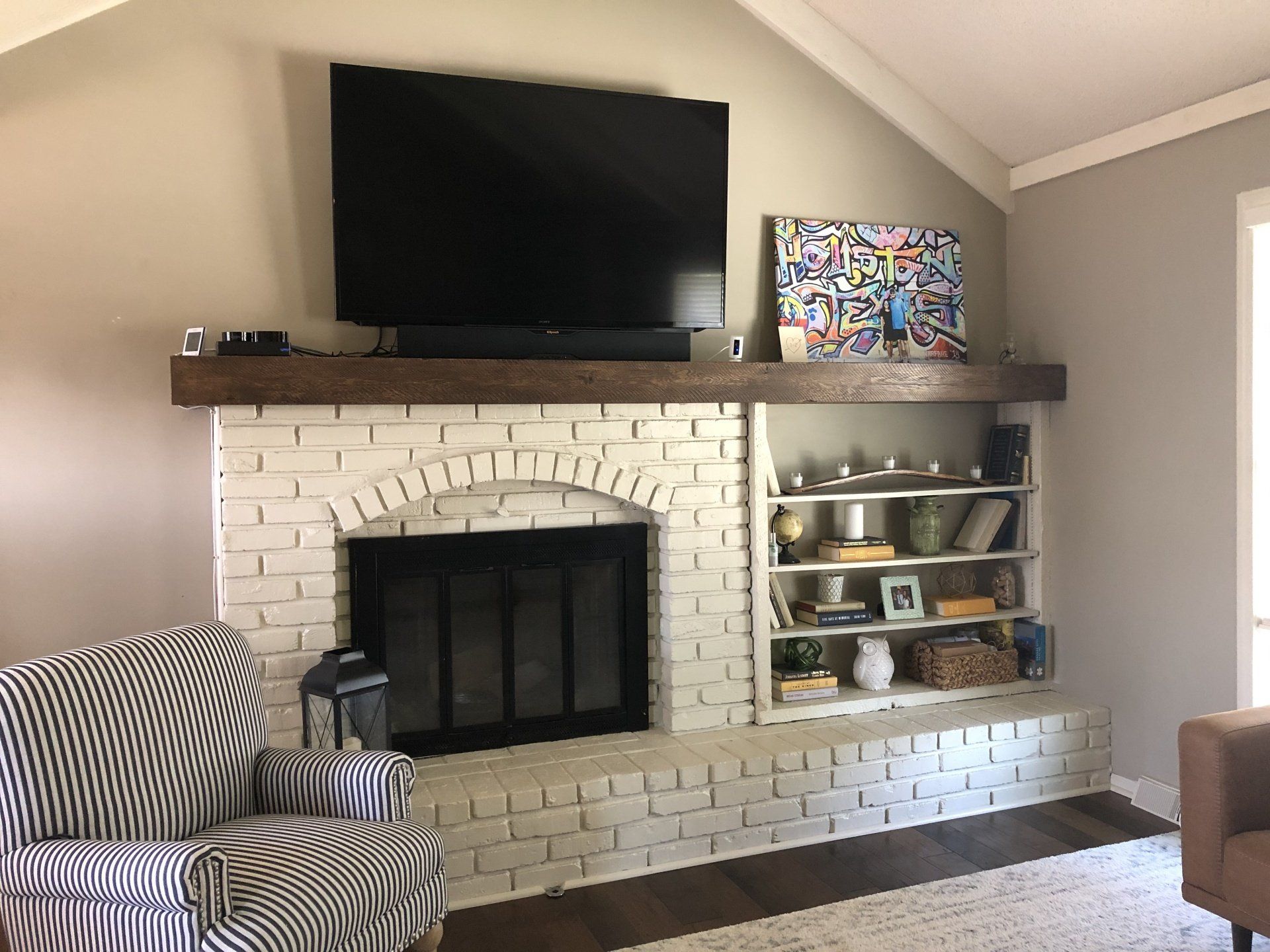 A living room with a fireplace and a flat screen tv.