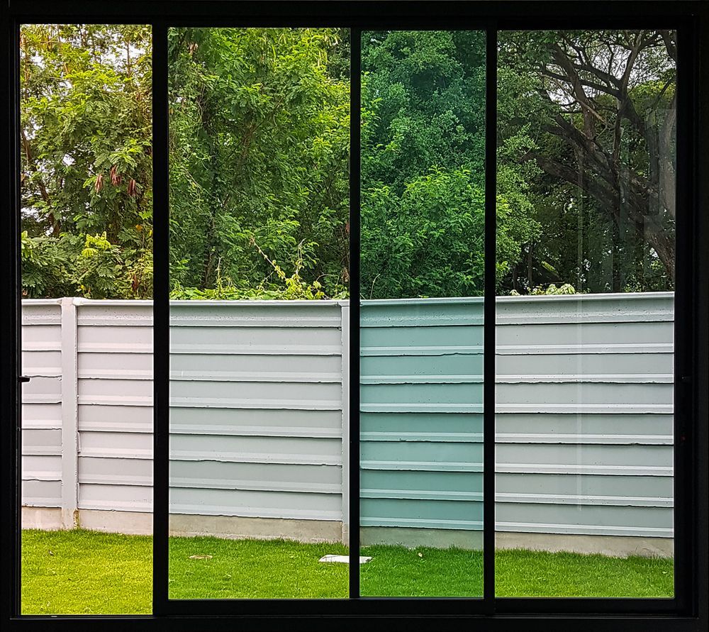 Backyard With White and Teal Fence Panels, Green Grass — ALUBEST Windows & Doors In Southport, QLD