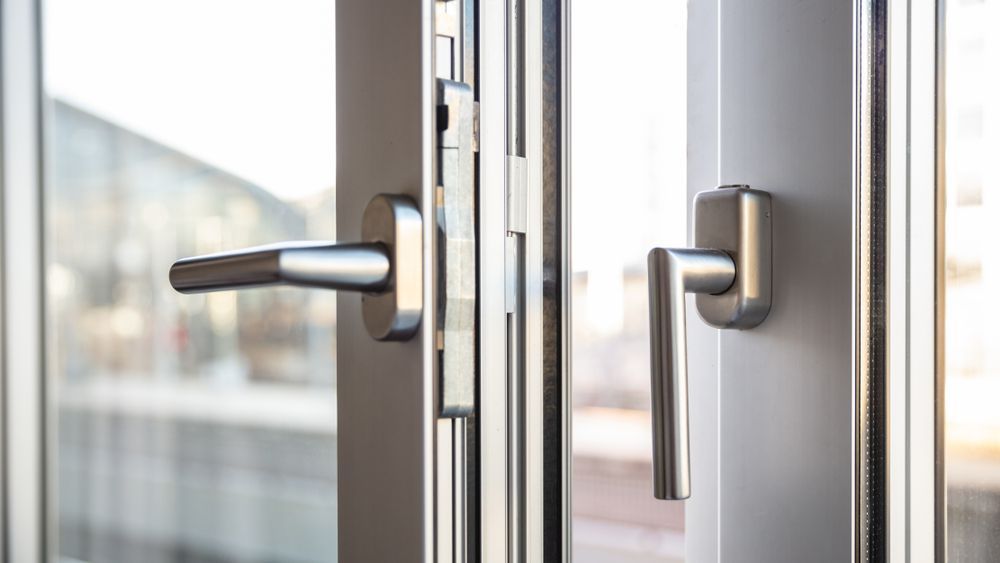 A Two Modern Metal Door Handles on a Glass Door Aluminium French Doors — ALUBEST Windows & Doors In Southport, QLD