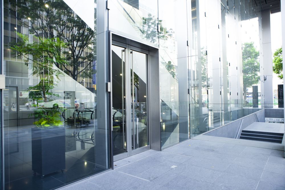 Modern Glass Office Entrance With Reflective Panels — ALUBEST Windows & Doors In Southport, QLD