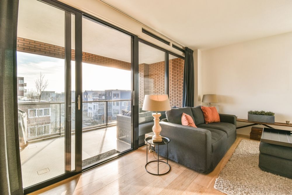 Bright Living Room With Black Sofa, Large Sliding Glass Doors — ALUBEST Windows & Doors In Southport, QLD