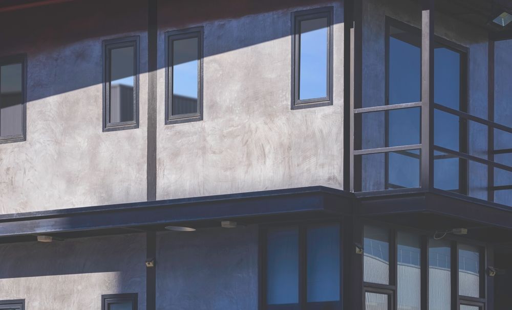 Modern Building Facade With Blue-trimmed Windows and a Glass Corner — ALUBEST Windows & Doors In Southport, QLD