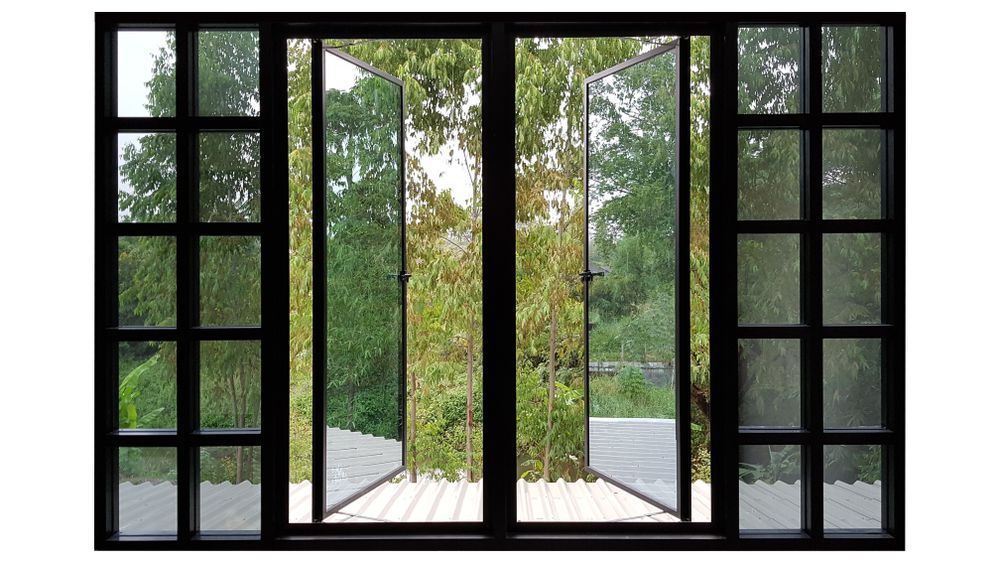 Black-framed Windowed Doors Open to a View of Trees and Greenery Outside — ALUBEST Windows & Doors In Southport, QLD