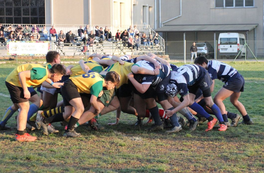 Un gruppo di giocatori di rugby è ammassato insieme su un campo.