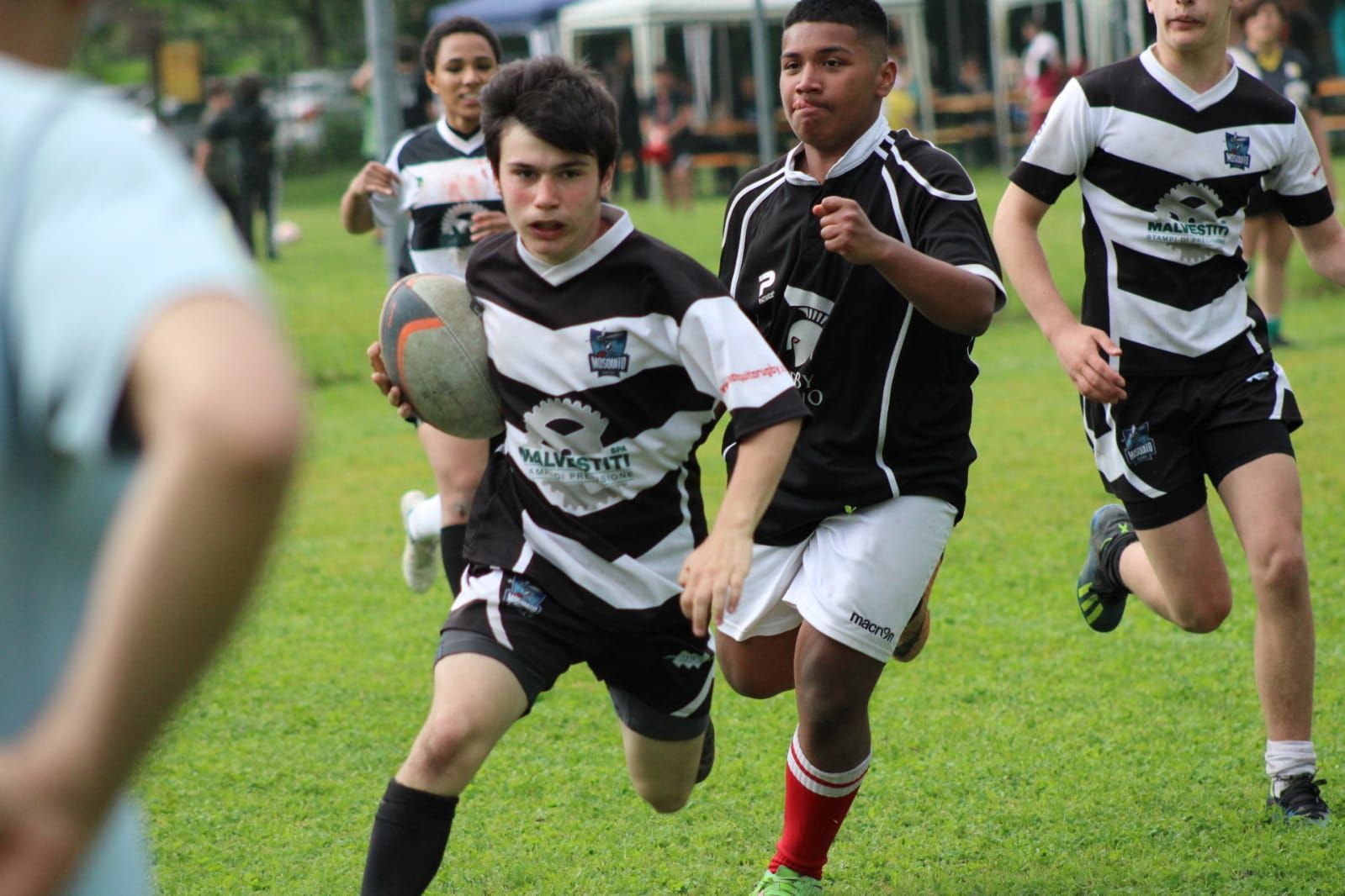 Un gruppo di giovani uomini sta giocando a rugby su un campo.