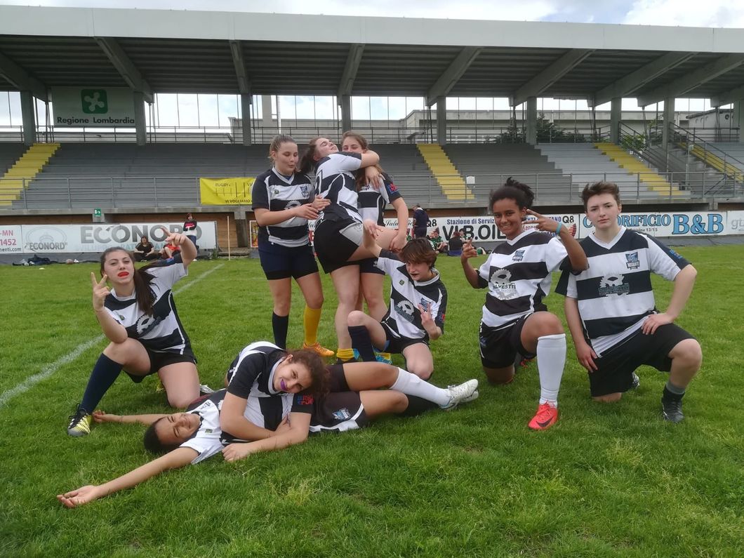 Un gruppo di persone posa per una foto su un campo da calcio.