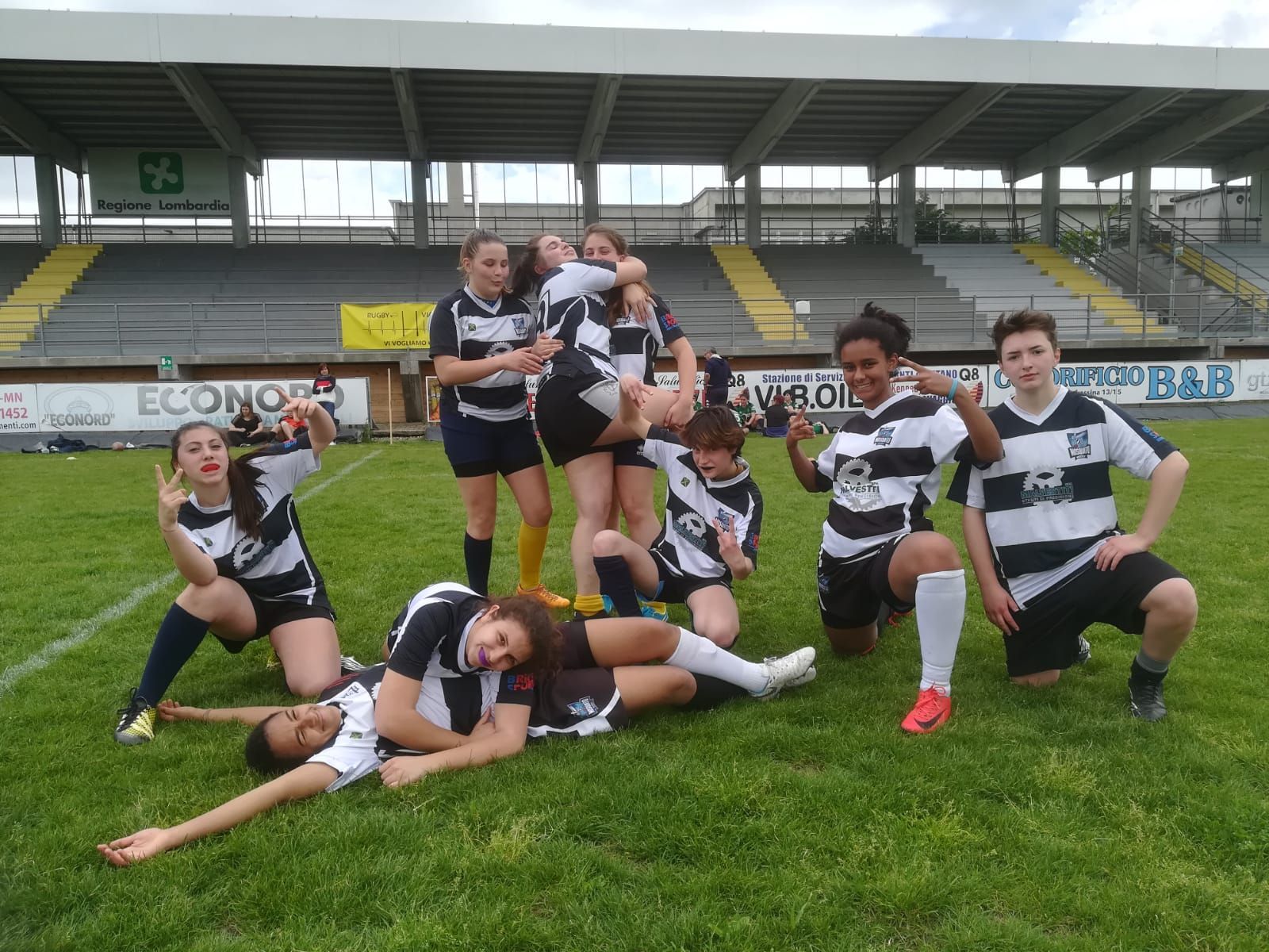 Un gruppo di persone posa per una foto su un campo da calcio.