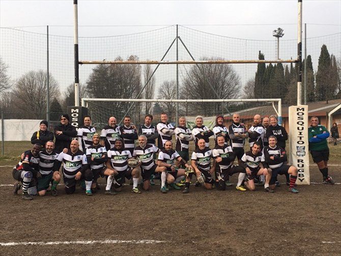 Un gruppo di giocatori di rugby posa per una foto su un campo
