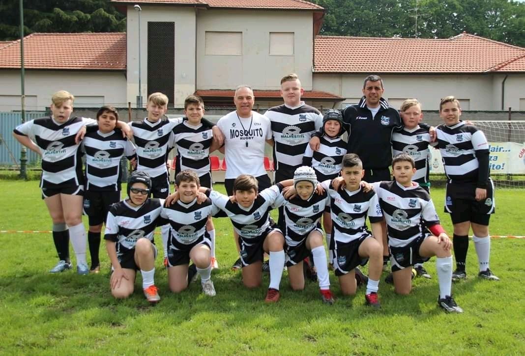 Un gruppo di ragazzi posa per una foto in un campo.