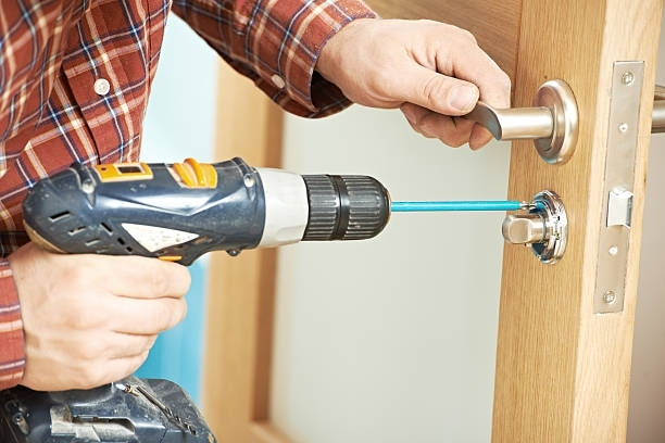 Carpenter installing door lock, showcasing professional skills in door installation.
