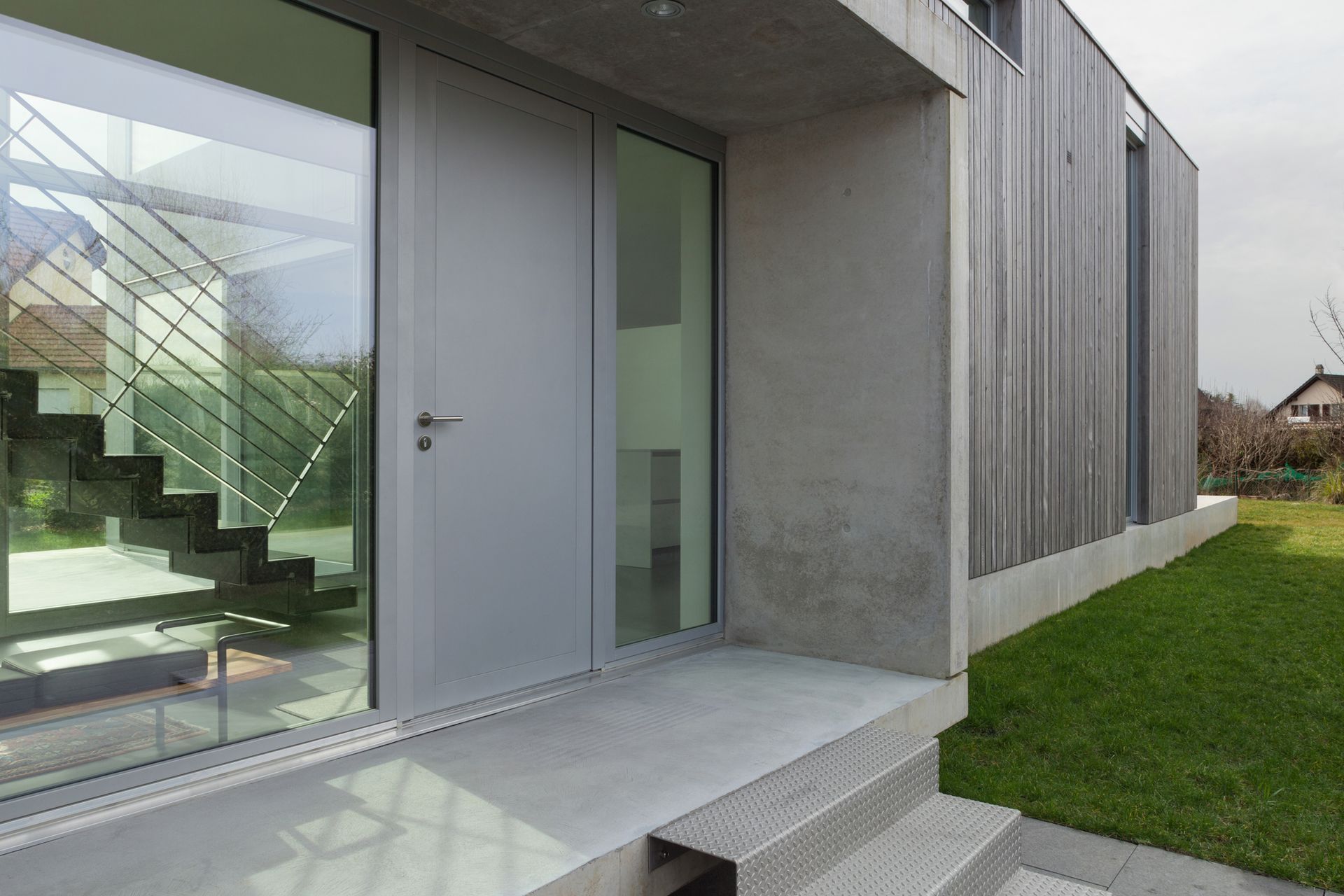 Modern house featuring a glass door and stairs, showcasing Thermalcraft’s elegant design. Ideal for