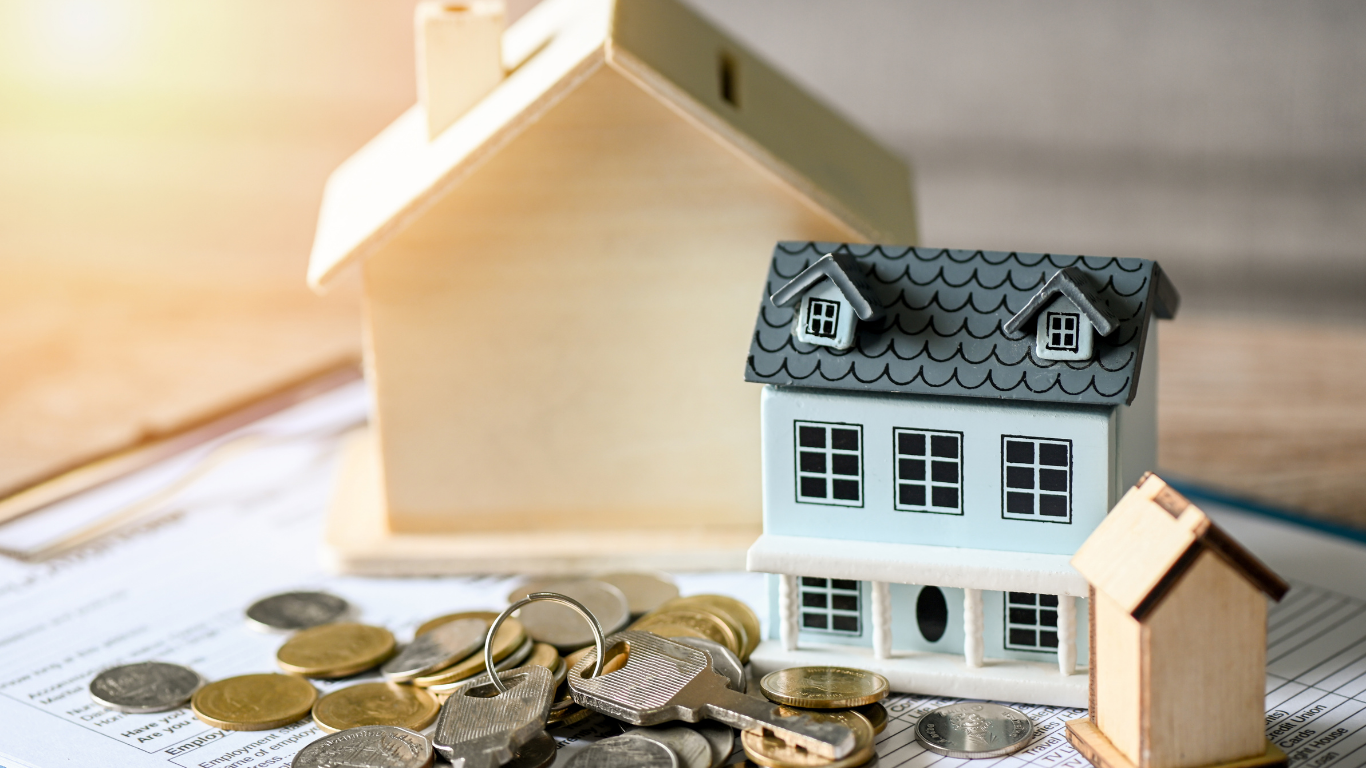 Miniature houses and coins on document, suggesting real estate investment.