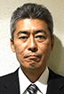 A man in a suit and tie is looking at the camera.