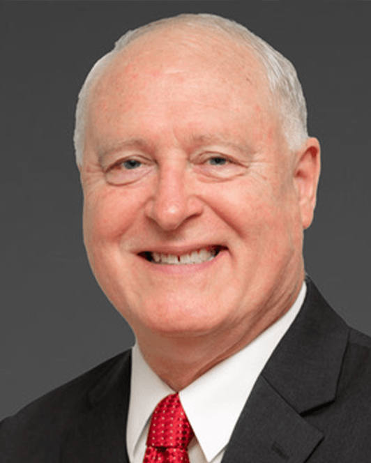 A man in a suit and tie smiles for the camera