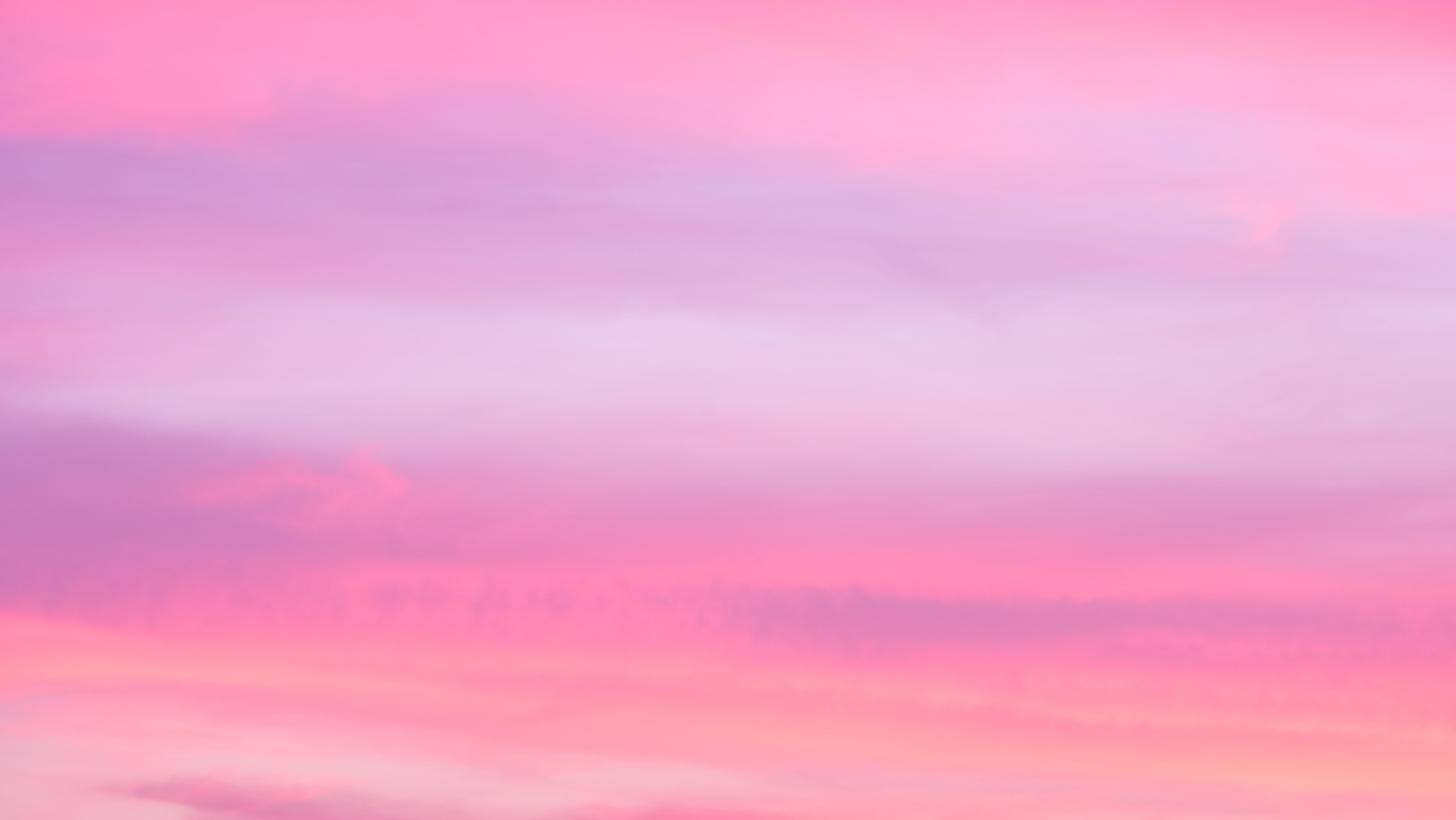 Soft pink and lavender clouds streak across a pastel sunset sky.