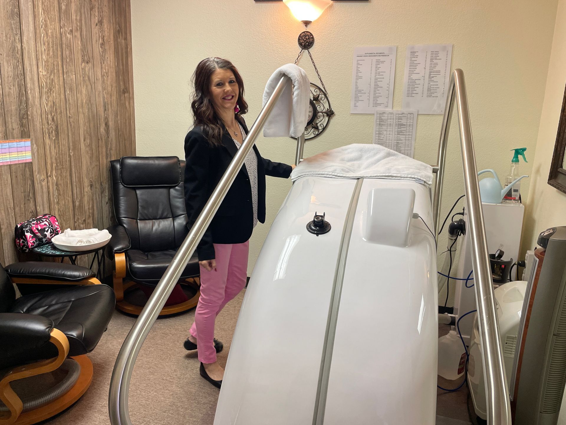 Woman standing beside a large white medical machine in a treatment room