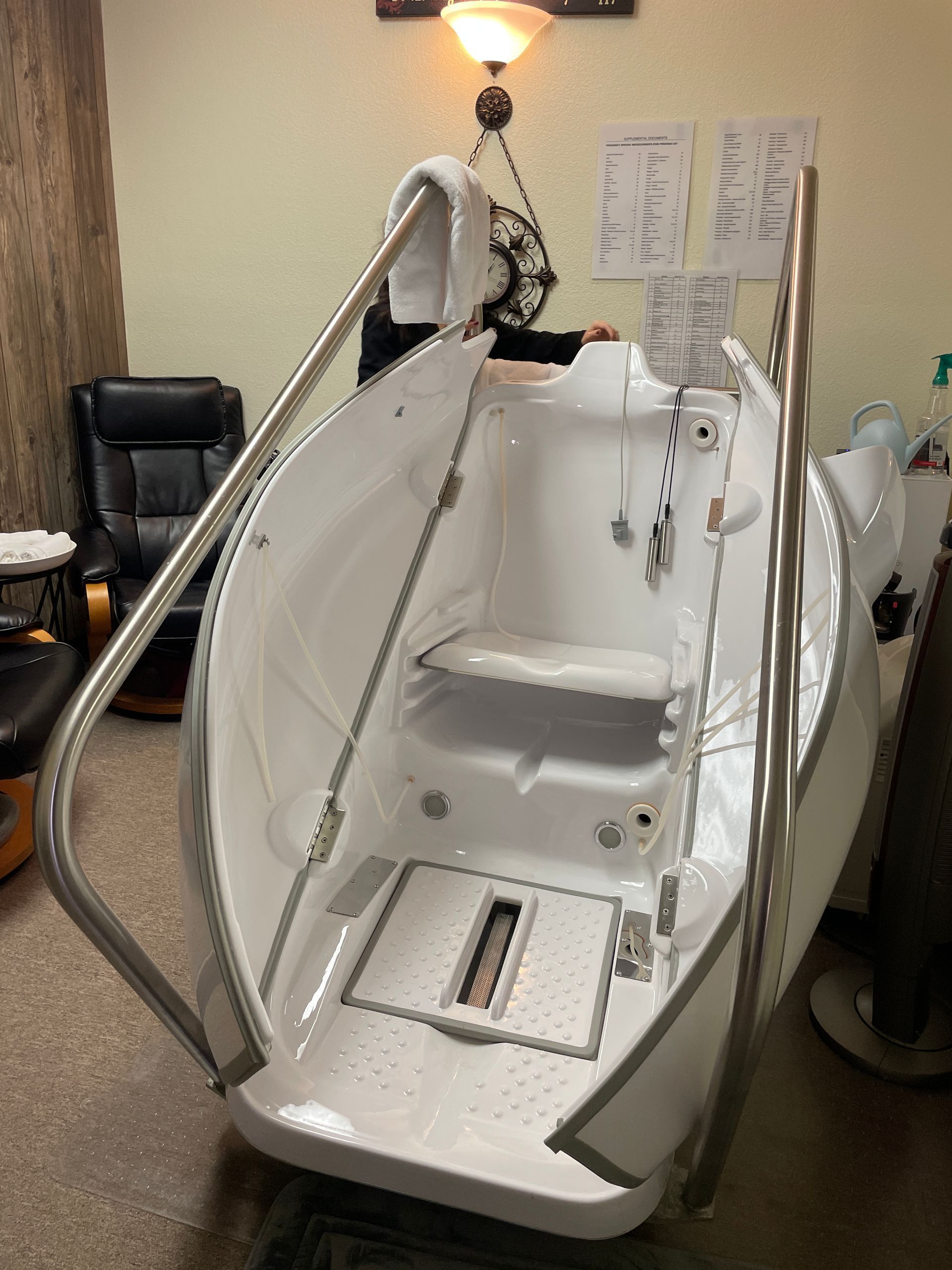 White enclosed mobility/patient lift chair with padded seat and headrest in a room