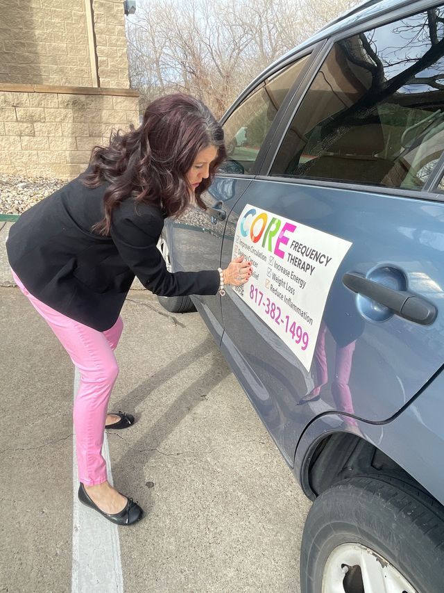 Person placing a sign on a car door in a parking lot
