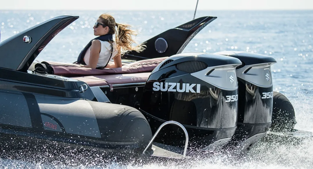 Donna su un motoscafo nero, due motori Suzuki, che si muove sull'acqua.