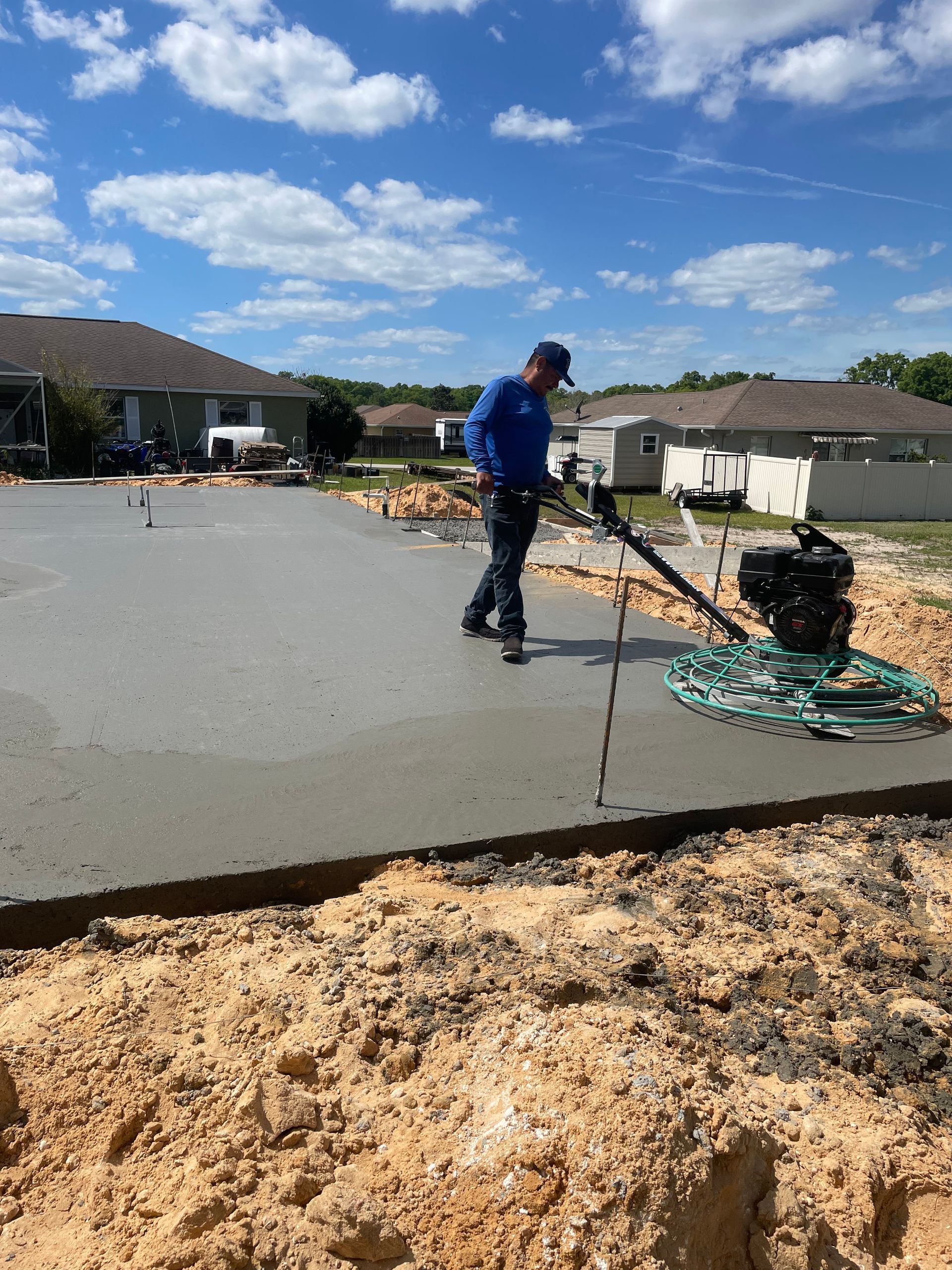 A man is using a machine to spread concrete on a construction site. Project done by C1 Foundations
