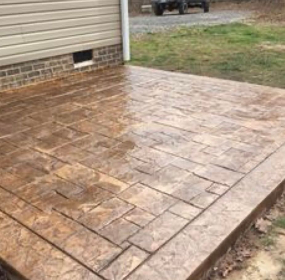 A concrete patio in front of a house with a jeep parked in the background. Project done by C1 Foundations