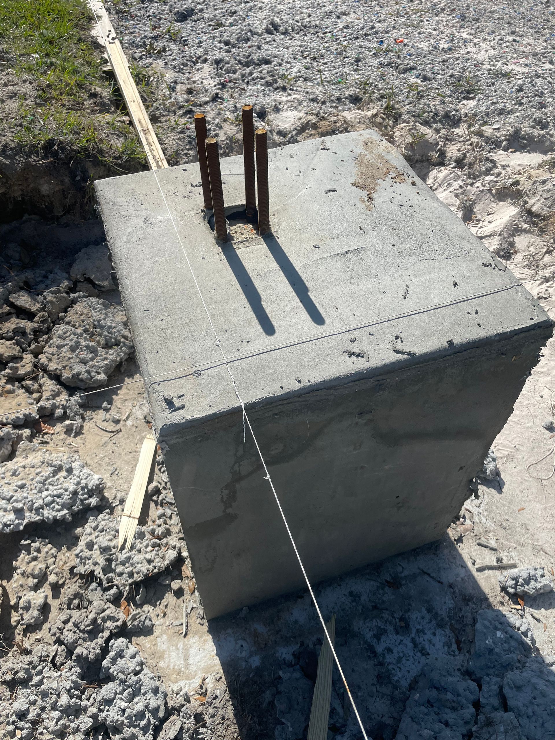 A concrete block is sitting on top of a pile of dirt. Project done by C1 Foundations
