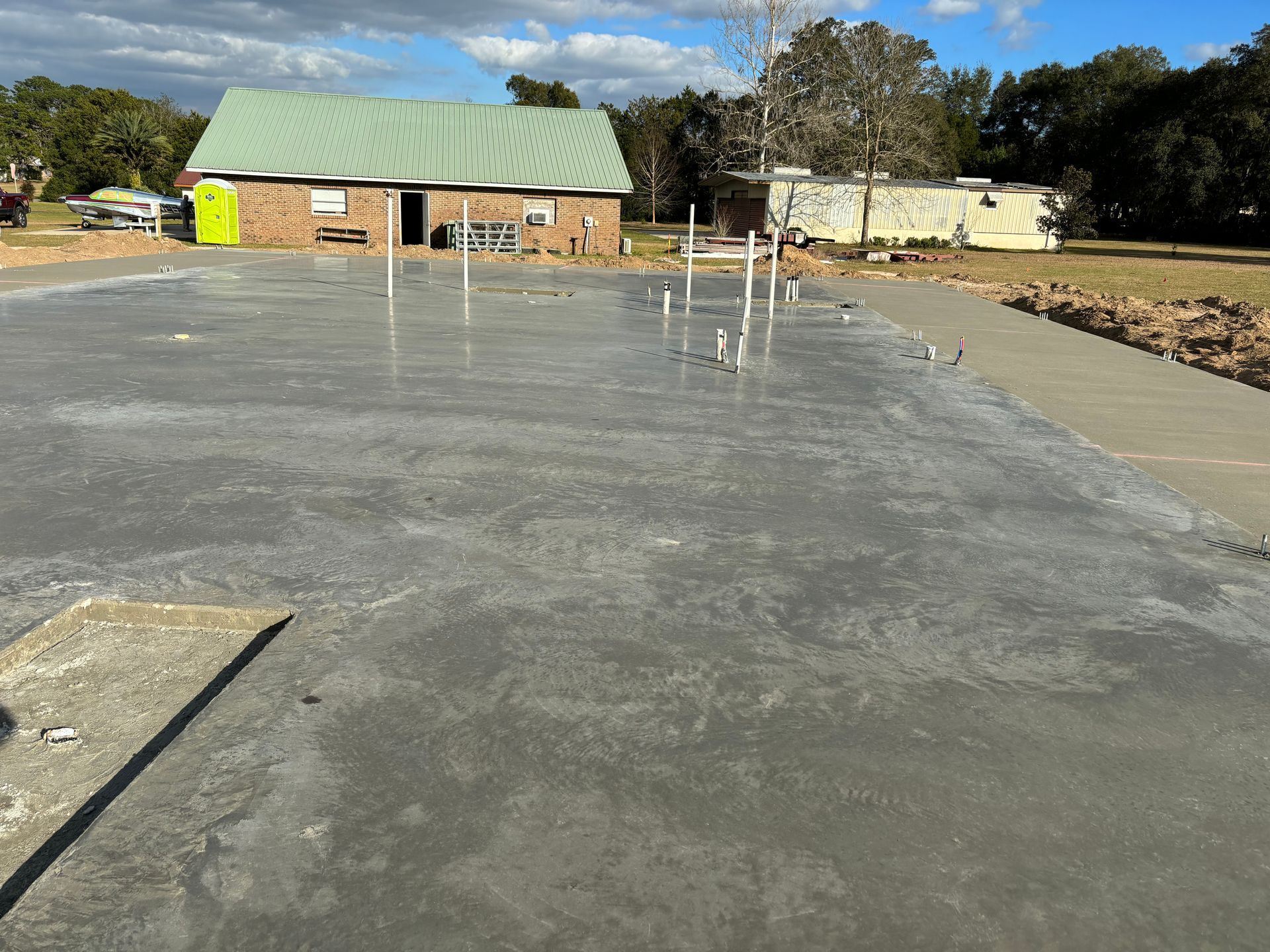 A concrete driveway with a house in the background. Project done by C1 Foundations