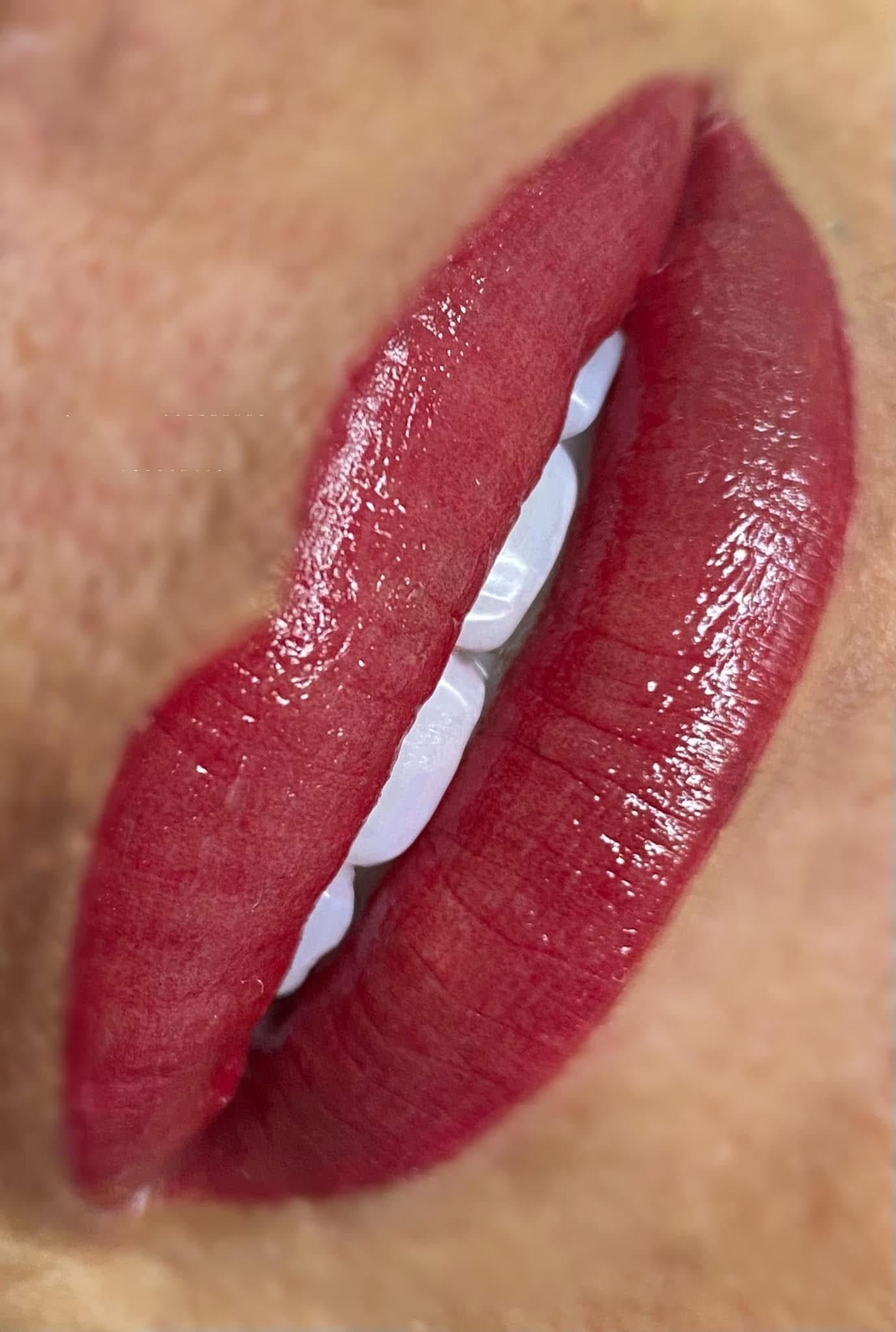 Red lipstick on plump lips, teeth visible.