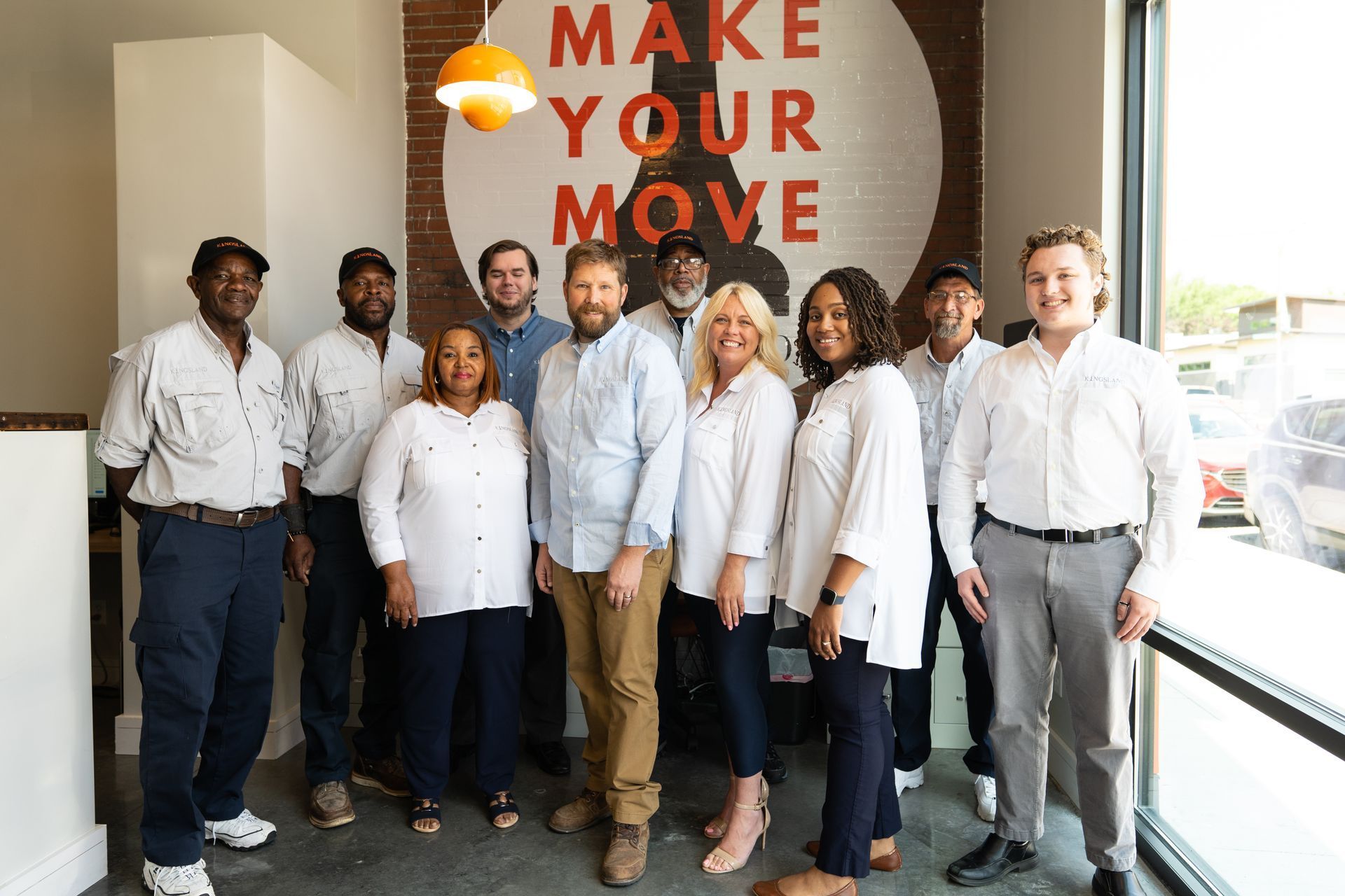 Group photo of Kingsland team members standing in front of office window
