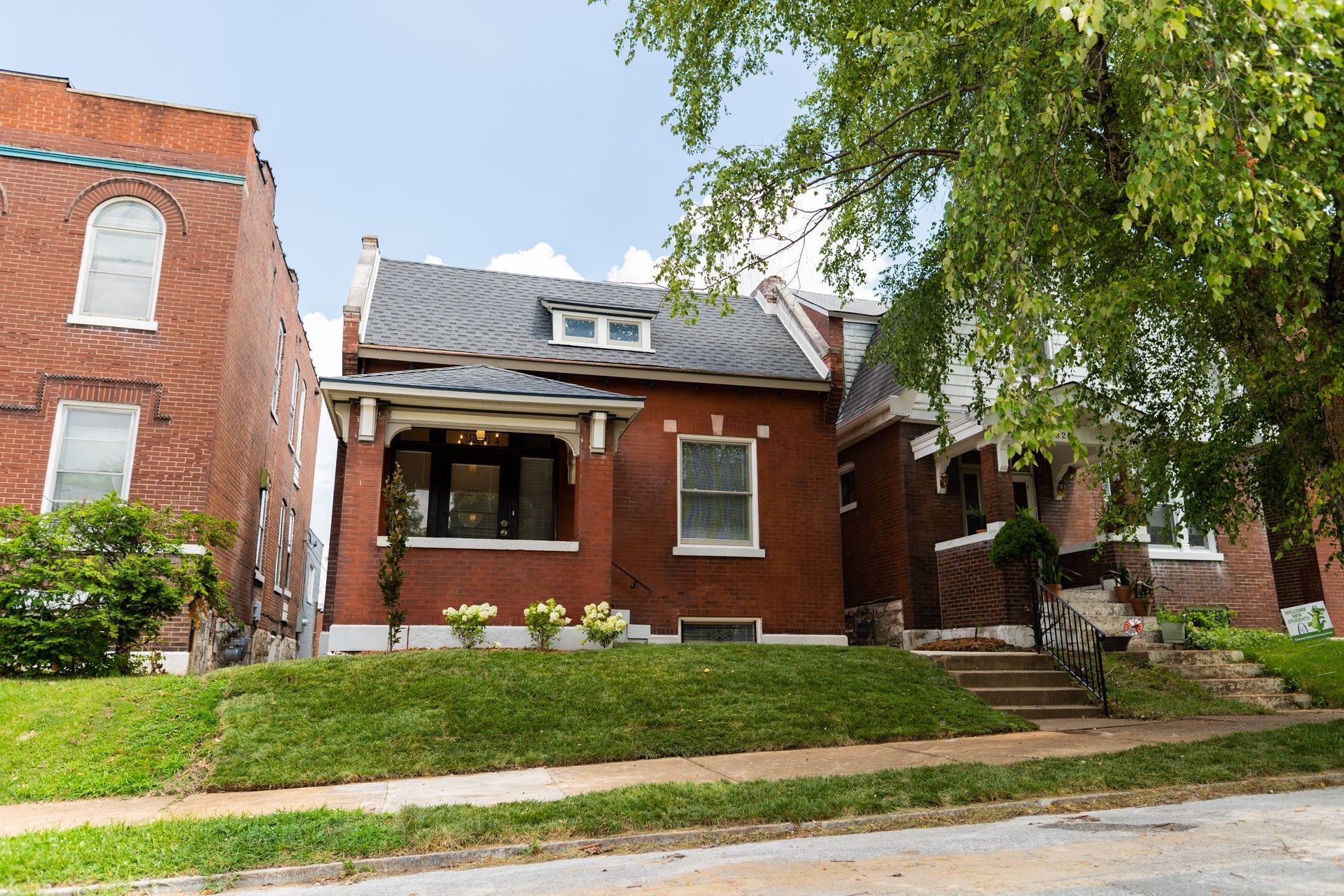 Exterior of a brick single-family home with mature landscaping