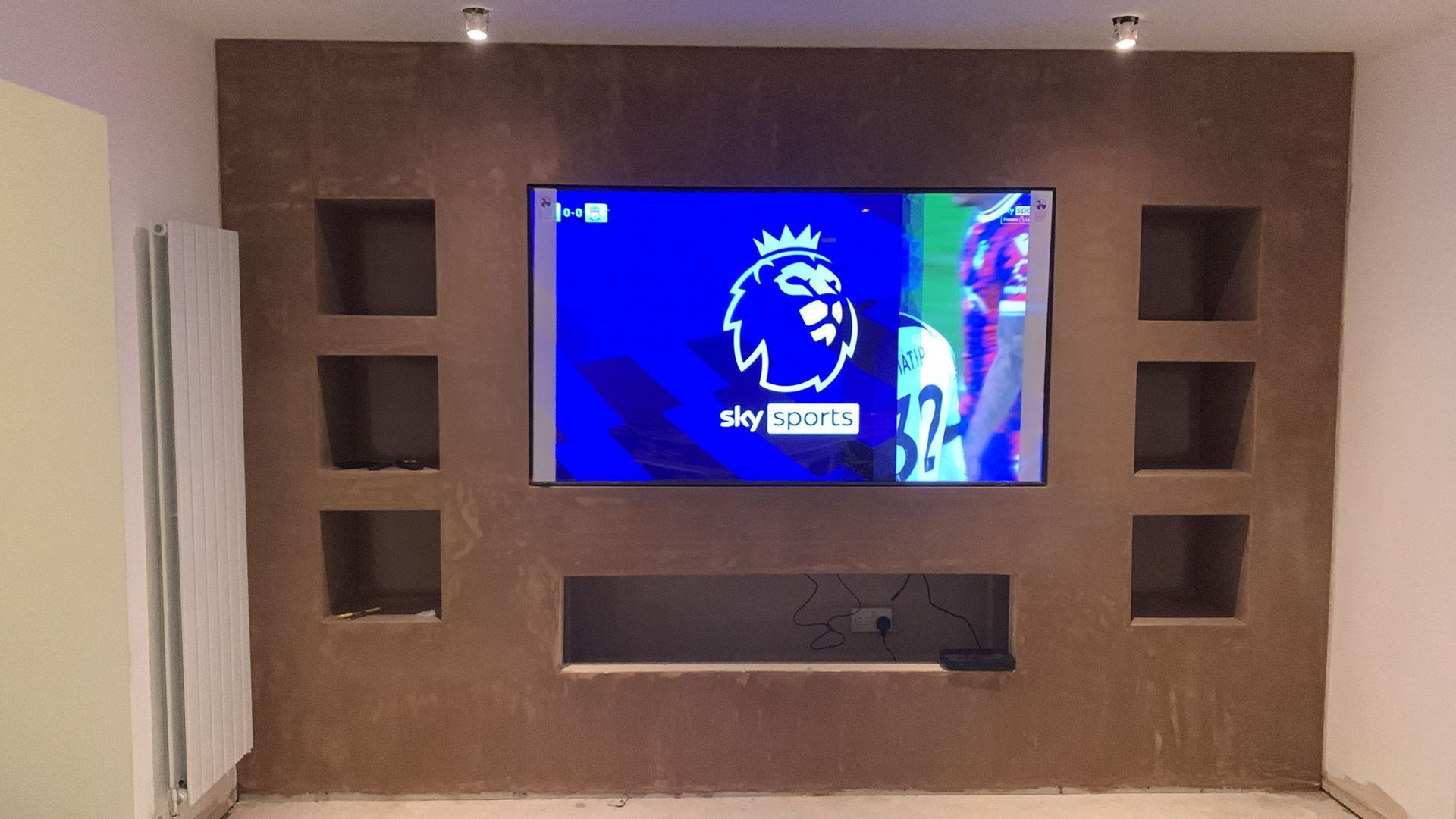 a media wall after plastering and TV installation. It has not been painted yet.