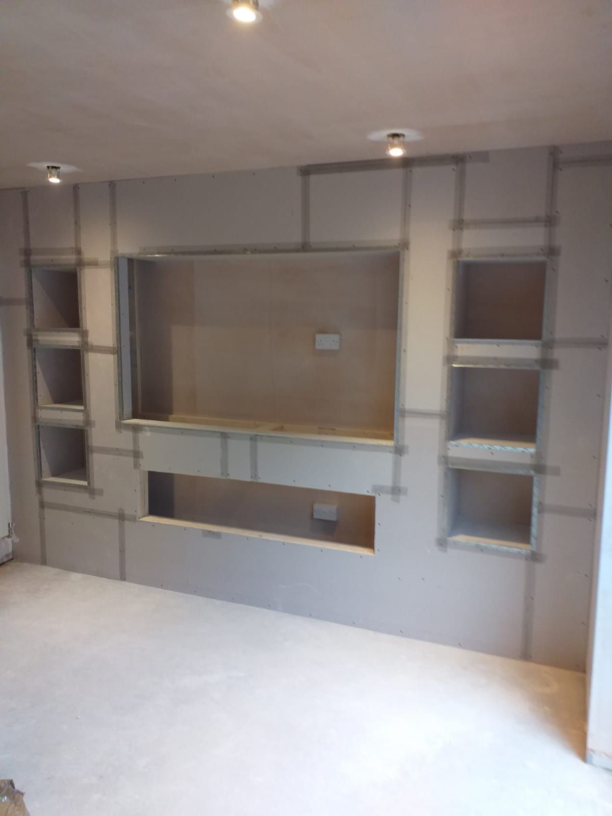 a media wall after being boarded, taped up, and with angle beads in place ready for plastering 