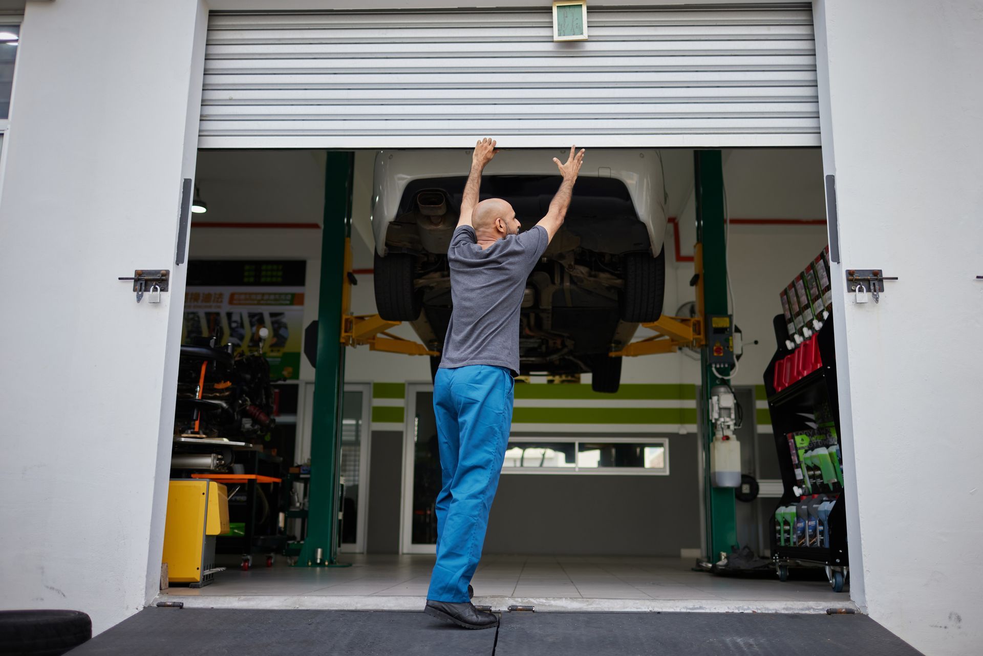 Man Opening Garage Steel Door — Cleveland, TN — McSpadden Garage Door Co
