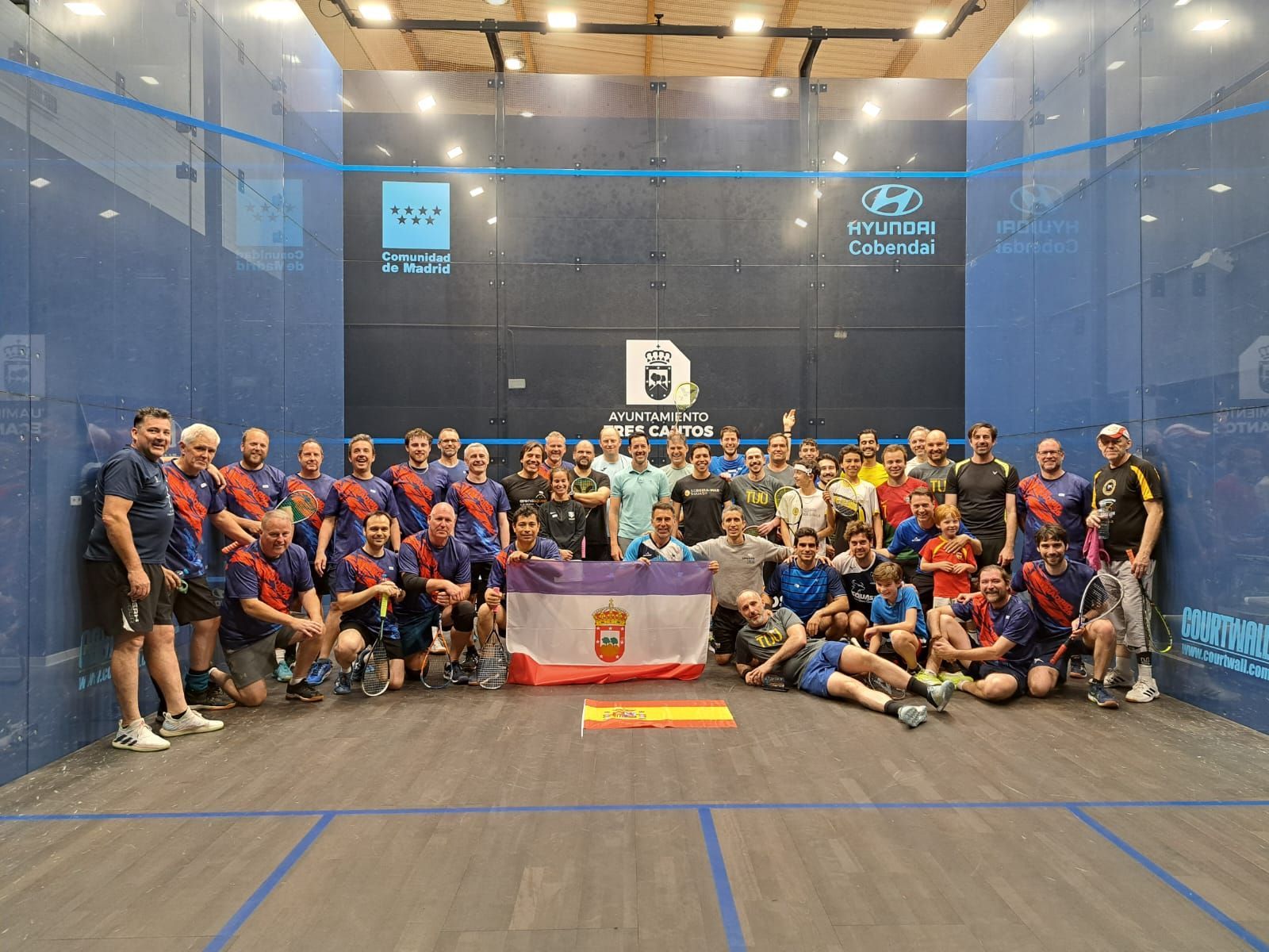 A close-up of a squash ball and racket on a wooden court floor during SquashFest 26 Stafford.