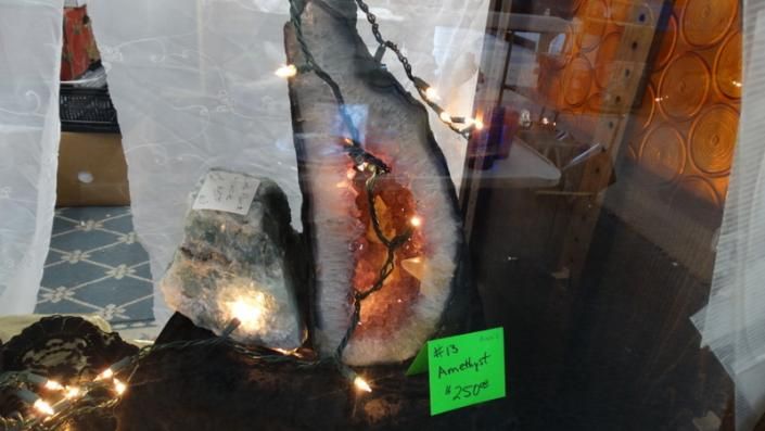 Decorative crystal lamps glowing on display with a green price tag in a shop window