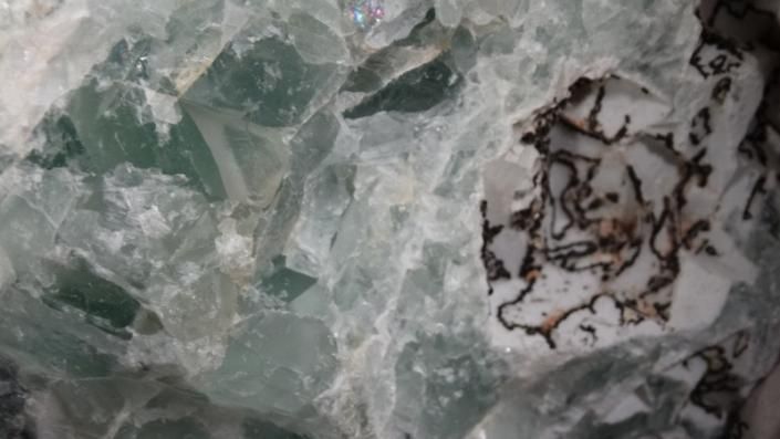Green and white marble-like surface with a dark brown veined patch on the right