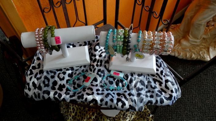 Bangle bracelets displayed on white stands over a leopard-print cloth