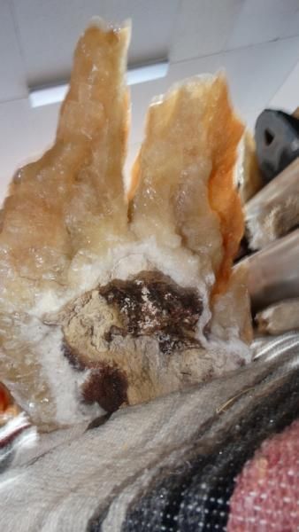 Close-up of a translucent amber rock with a dark, rough center on a patterned fabric surface.