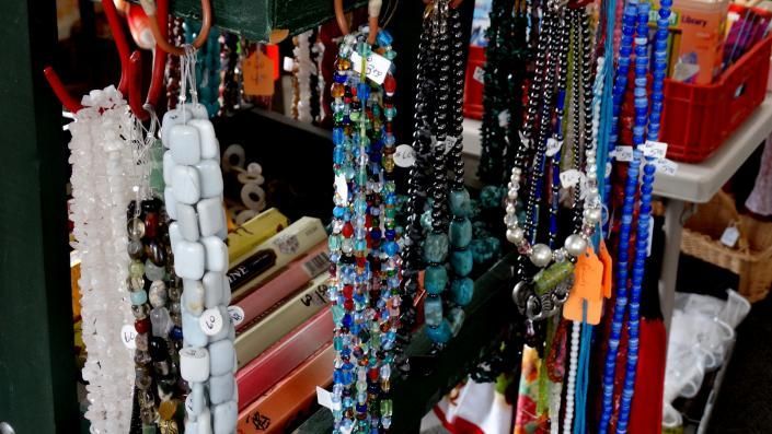 Colorful beaded necklaces and hanging ornaments displayed in a shop stall