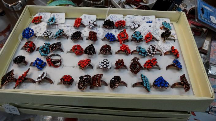 Tray of small red, blue, and black beetle-shaped objects arranged in rows on a white surface